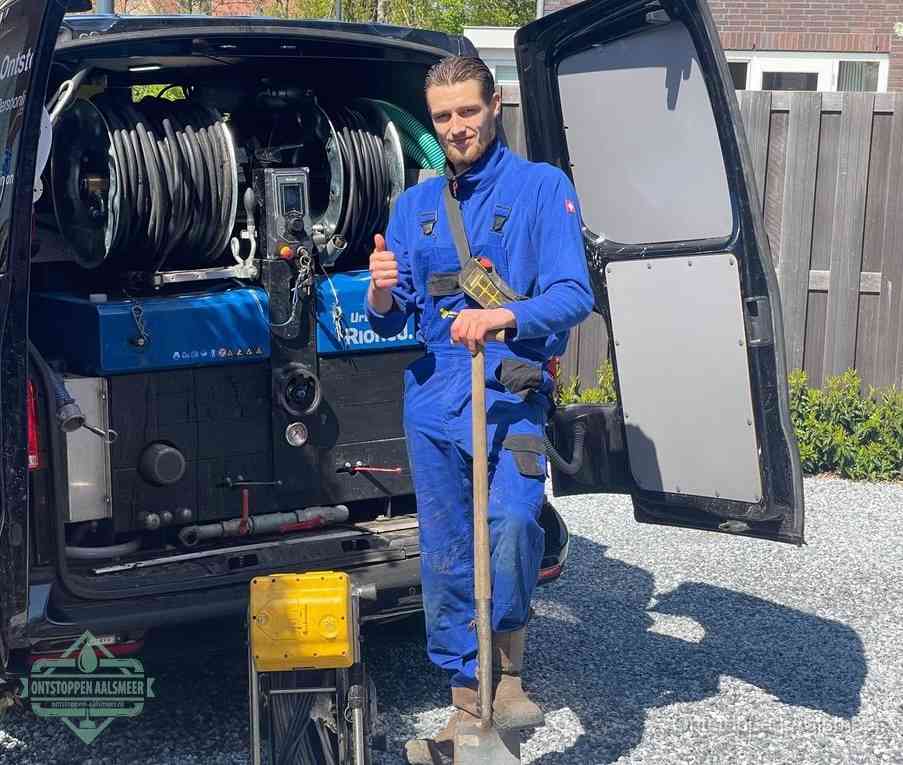 Een tevreden monteur met opgestoken duim naast de bestelbus, slim ingrijpen bespaart kosten bij een verstopte afvoer in Aalsmeer