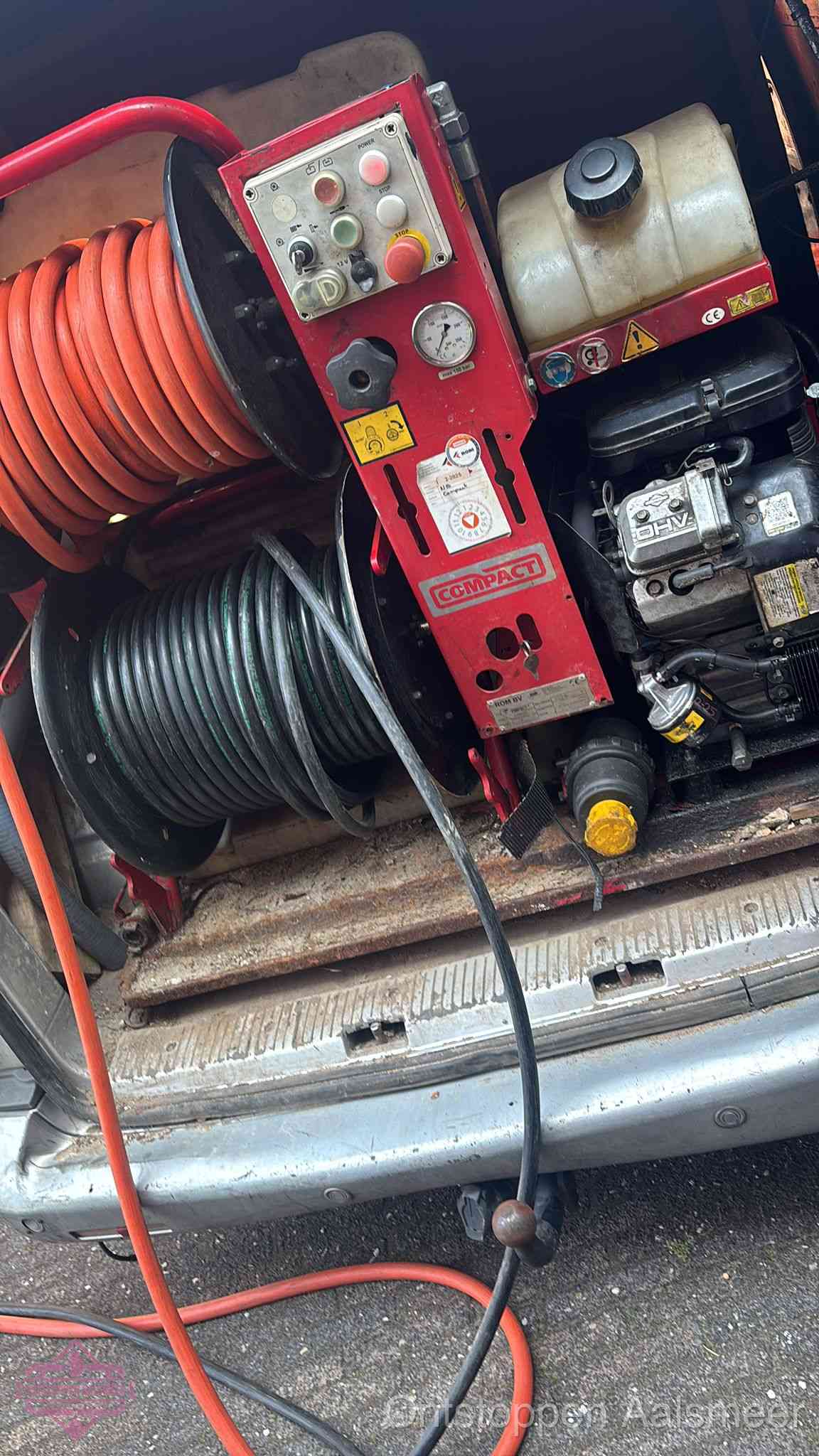 Een rood hogedruk-rioolreinigingstoestel met slangen in de laadbak van de bedrijfsbus, apparatuur voor een hardnekkige wc-verstopping in Aalsmeer