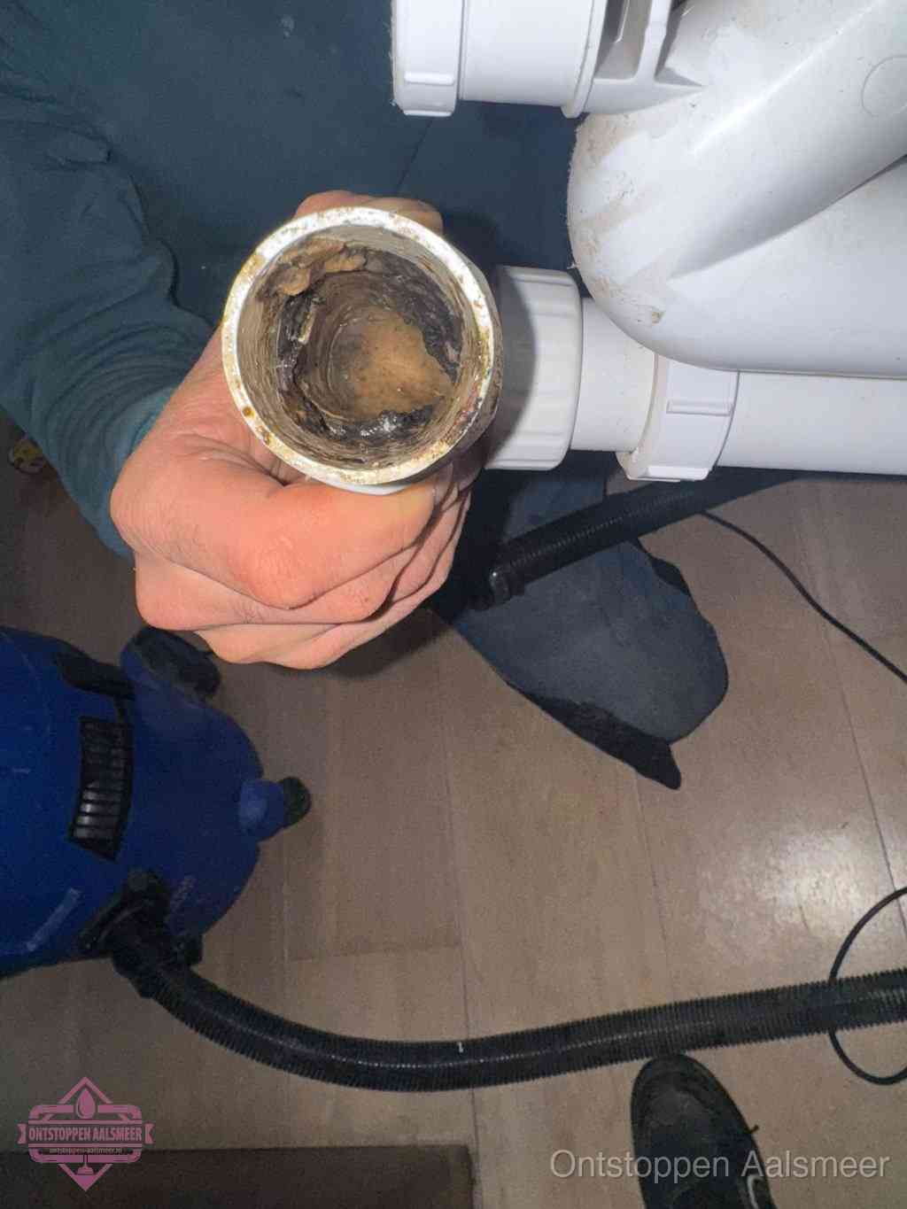 Een losgekoppelde afvoerbuis die van binnen volledig is dichtgeslibd met vet en aanslag, de meest voorkomende oorzaak van een verstopte gootsteen in Aalsmeer