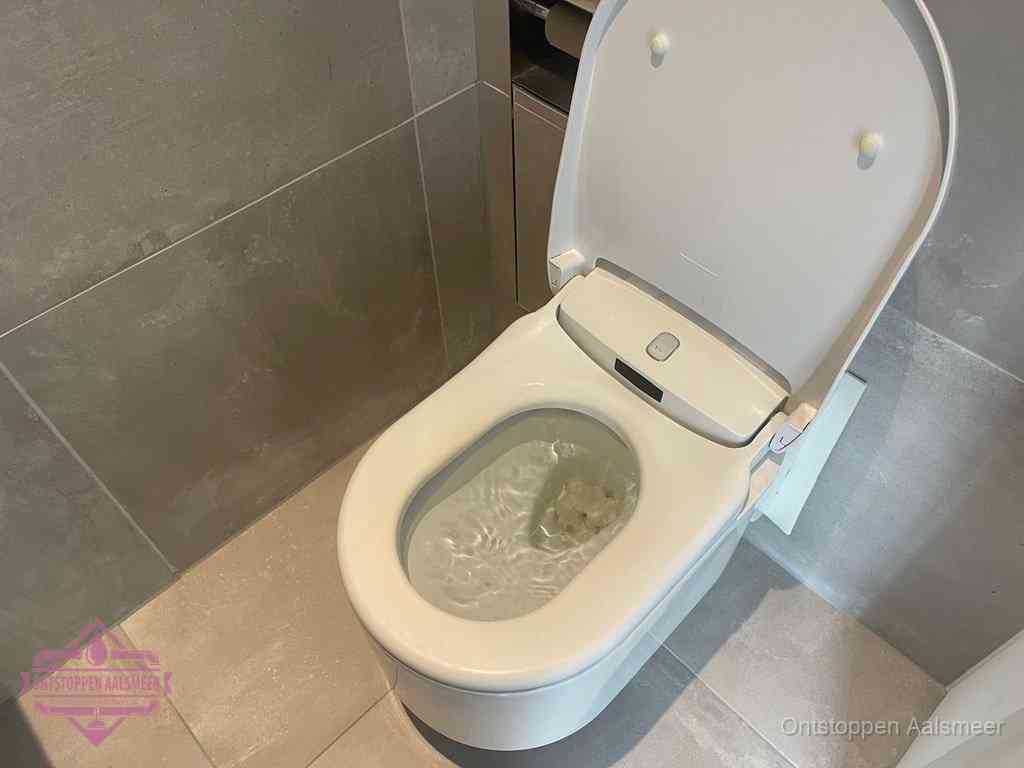 Een toiletpot vol troebel water met drijvend papier en restanten, de meest voorkomende oorzaak van een verstopte wc in Aalsmeer