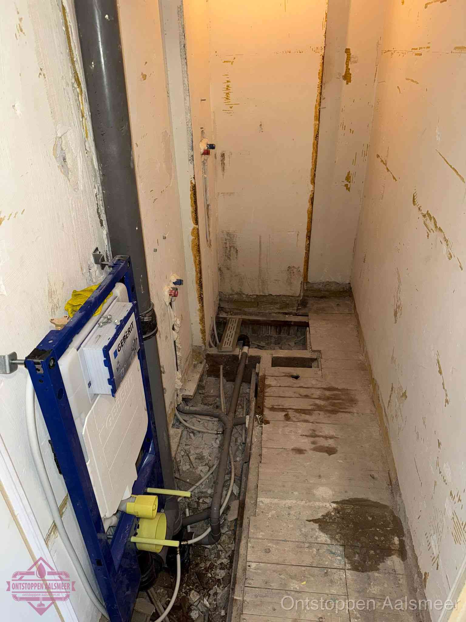 Een opgebroken toiletruimte tijdens renovatie met een Geberit inbouwreservoir en blootliggende oude afvoerleidingen, typisch voor oudere woningen in Aalsmeer